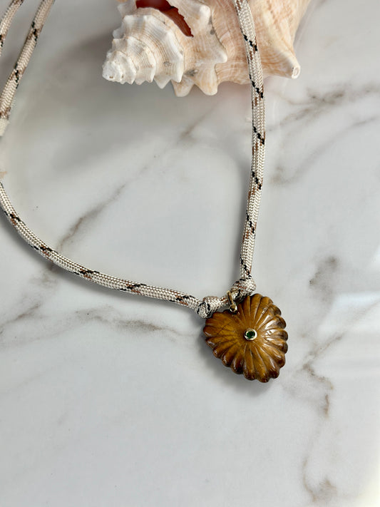 Cream patterned paracord necklace with carved amber stone pendant and green CZ center detail.
