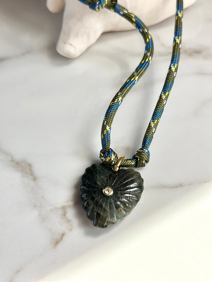Dark green carved stone pendant necklace with olive and blue woven paracord cord and gold-tone details.