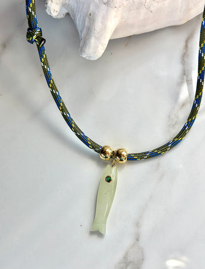 Natural green jade fish pendant necklace with CZ eye, gold-tone beads and olive blue patterned adjustable cord.

