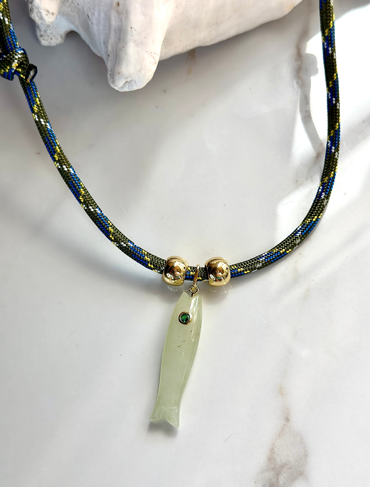 Handmade green jade fish pendant necklace with CZ eye, gold-tone beads and patterned adjustable cord.
