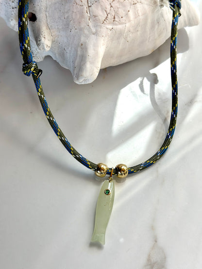 Adjustable cord necklace with natural green jade fish pendant and gold-tone bead accents styled with a seashell.
