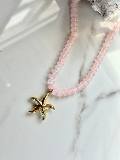 Pink and gold natural gemstone necklace featuring a textured starfish pendant.

