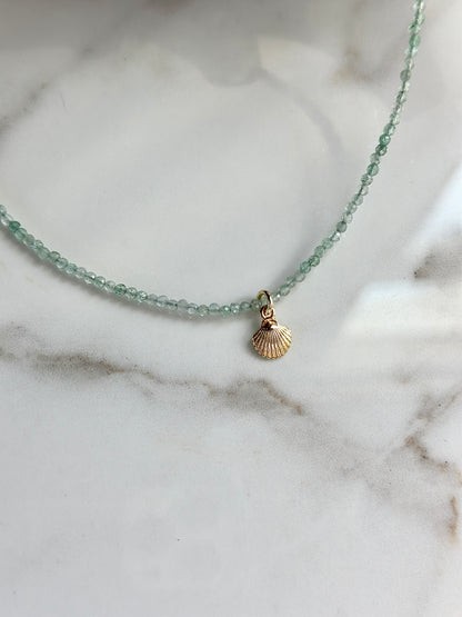 Pale green Green Strawberry gemstone bead necklace with a petite gold shell charm.
