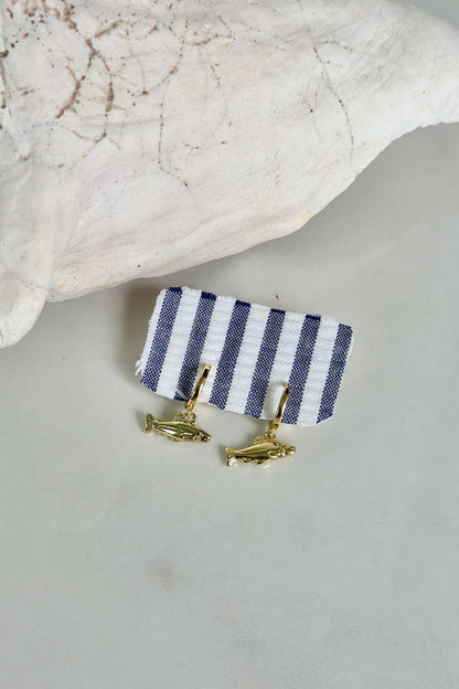 Gold Catch Hoops gold huggie earrings with gold marlin fish charm on navy stripe earring card, styled on coral