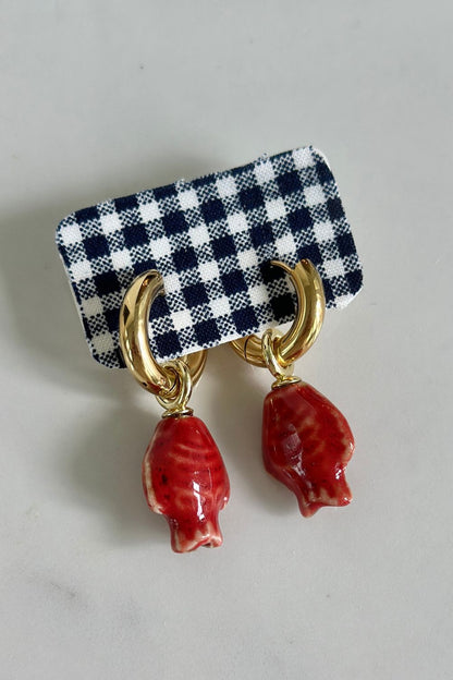 Harbor Red Hoops gold huggie earrings with red ceramic fish charm on navy gingham earring card
