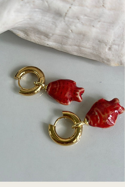 Maritt Row Harbor Red Hoops gold huggie earrings with red fish charm, product detail shot

